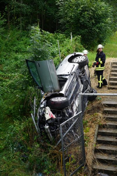 PKW kommt von Fahrbahn ab und landet neben einer Bruecke und beginnt zu brennen